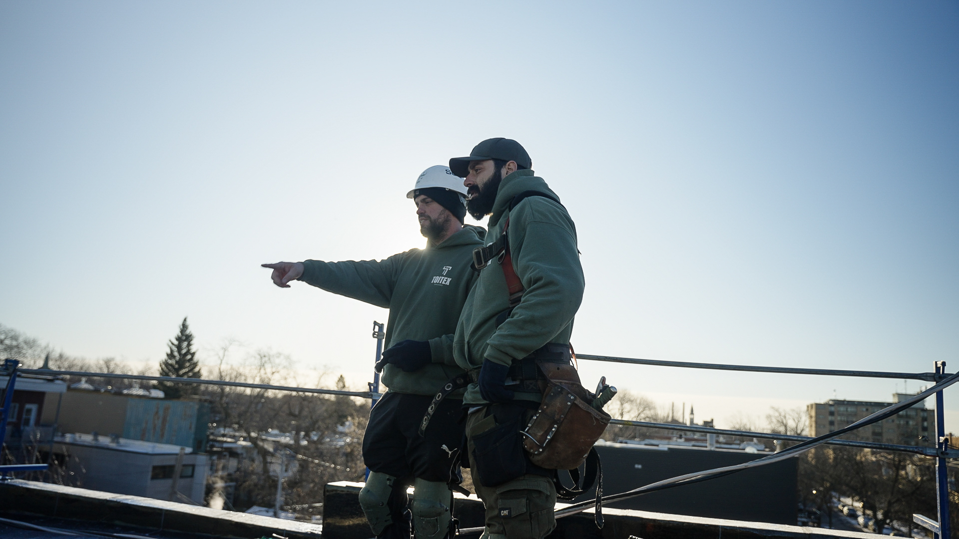 Équipe Toitex en uniformes verts sur un chantier de toiture